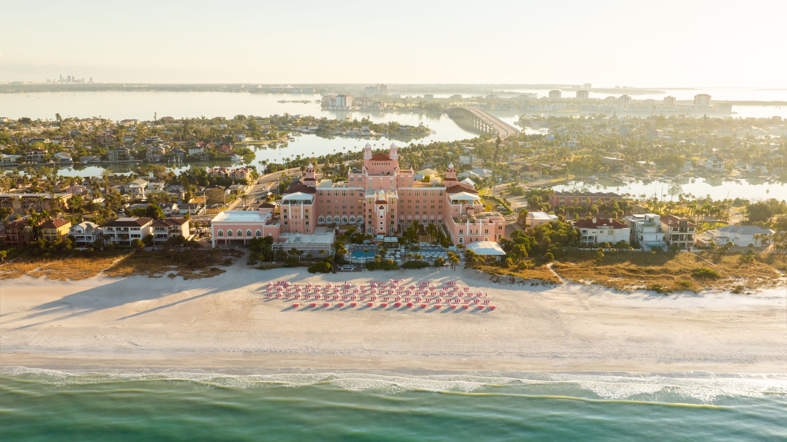Aerial drone view of The Don CeSar, the pink Mediterranean-style hotel on St. Pete Beach with the Gulf of Mexico beyond.